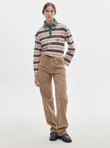 Pantalón de pana roja con corte holgado y tiro medio. Presenta una línea dorada a lo largo de la pierna.