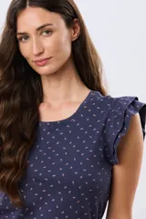 Remera de algodón color beige con sutil estampado, cuello redondo y mangas cortas con doble volado aportando volumen y un diseño femenino.