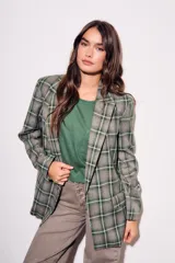 Blazer de corte recto con estampado de cuadros en tonos verdes y grises. Presenta solapas clásicas, cierre frontal y bolsillos laterales.