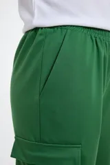 Pantalón tipo babucha estilo cargo color verde, con cintura y puños elásticos, bolsillos laterales funcionales y corte holgado.