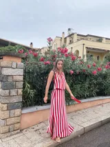 Falda larga tejida a rayas verticales rojas y blancas, con pretina elástica y tajos laterales.