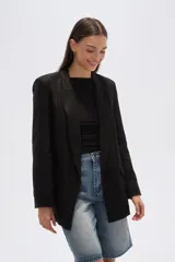 Blazer negro de corte holgado con cuello solapa y bolsillos frontales.