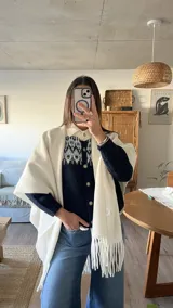 Cardigan de punto en color azul marino con diseño jacquard en tonos celestes y blancos en la parte superior. Presenta cuello redondo, cierre frontal con botones y mangas largas.