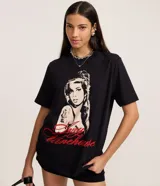 Remera de algodón negra con cuello redondo y manga corta. Presenta un estampado grande en tonos blanco y rojo de la cantante Amy Winehouse, con su firma en letra cursiva roja debajo.