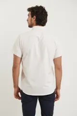 Camisa de manga corta a rayas verticales blancas y celestes, con cuello abotonado y bolsillo en el pecho.