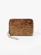 Billetera de cuero con textura de pelo animal print, diseño compacto y cierre perimetral con tirador de flecos.