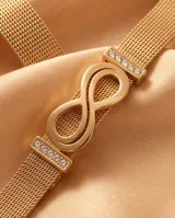 Pulsera de acero con baño de oro, con diseño de símbolo de infinito y barras con circonias en los laterales, tipo malla milanesa.