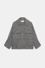 Chaqueta corta gris de tejido texturizado con cuello solapa, manga larga con trabilla, bolsillos delanteros con solapa y cierre frontal de botones metálicos.