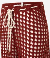 Pantalón de playa de crochet color ladrillo, con corte acampanado y cintura ajustable con cordón blanco.