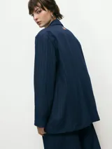 Blazer de corte sastrero en color azul marino con diseño de rayas diplomáticas. Presenta solapas clásicas, cierre frontal con un botón y bolsillos laterales con solapa.