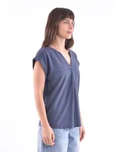 Blusa blanca de corte holgado, con cuello en V y mangas cortas.