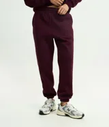 Pantalón jogger de mujer confeccionado en tejido fleece de algodón y poliéster. Presenta un corte holgado con cintura elástica y puños ajustados en el bajo.
