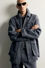 Parka relaxed fit de algodón color gris con efecto lavado. Cuenta con cuello solapa, cuatro bolsillos de plastrón con solapa en el frente y cierre frontal con cremallera oculta por solapa con botones a presión.