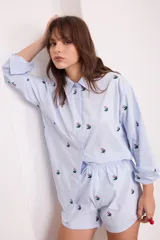 Short negro de algodón con bordados de pequeñas flores rosas y verdes, cuenta con cintura elástica y cordón ajustable.