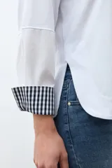 Remera blanca de manga larga con cuello redondo y puños con estampado de cuadros vichy en azul y blanco.