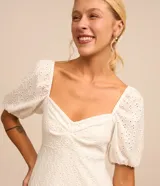 Vestido midi de broderie color blanco, con escote corazón, mangas cortas abullonadas y diseño texturizado.
