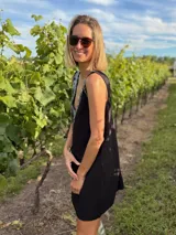 Vestido corto negro de gabardina con corte suelto y escote en V en frente y espalda. La parte delantera está adornada con flecos de lentejuelas plateadas.