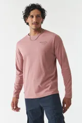 Remera de manga larga color rosa con cuello redondo y logo estampado en el pecho.
