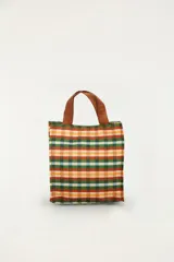 Bolso pequeño de mano con diseño a cuadros multicolor y asas superiores de color marrón. Cuenta con una correa extraíble y un parche frontal con el logo de la marca.