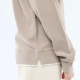 Sweater de tejido nido de abeja color beige, con cuello redondo, mangas largas y puños elastizados acanalados.