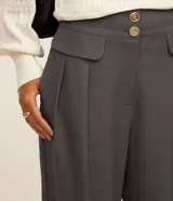 Pantalón de vestir negro, de corte wide leg, con cintura alta, bolsillos laterales y traseros.