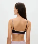 Soutien tipo bralette de diseño seamless en color marrón oscuro, con ribetes en contraste color blanco y banda inferior en color lila. Presenta copas desmontables y breteles finos ajustables.