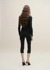Pantalón capri negro de punto, ajustado y de tiro medio.