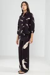 Pantalón amplio negro con estampado de sirenas en color crema, cintura elastizada y silueta fluida.