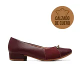 Zapato casual de cuero color bordó, con diseño ergonómico especial para juanetes. Presenta un panel frontal de tejido elástico para mayor flexibilidad, taco bajo cuadrado y un detalle metálico decorativo en la puntera.