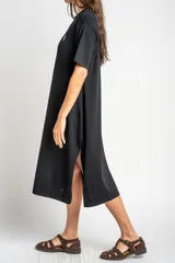 Vestido midi de punto negro con pequeño bordado de un velero en el pecho, mangas cortas y tajo lateral en el dobladillo.