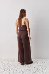 Pantalón wide leg de tiro medio y calce amplio, color marrón, con pinzas delanteras, cierre frontal y bolsillos laterales funcionales.