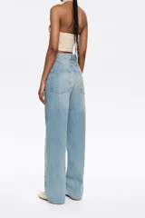 Pantalón vaquero celeste de corte wide leg, tiro bajo, con cierre frontal con botón denim y cinco bolsillos.