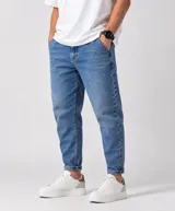 Jean slouchy de corte relajado, color azul medio con lavado clásico y diseño de tiro medio.
