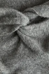 Vestido midi ajustado confeccionado en punto fino, con diseño de hombros descubiertos y detalle de nudo en el escote. Presenta mangas largas y una silueta entallada.