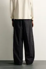 Pantalón cargo de corte relajado confeccionado en algodón con efecto lavado. Presenta bolsillos laterales tipo plastrón en las perneras, bolsillos frontales y bolsillos traseros de vivo. Incluye cierre frontal con cremallera y botón.