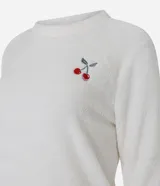 Pijama largo compuesto por dos piezas de tejido fleece suave. La blusa es de cuello redondo y manga larga, con un pequeño bordado de cereza en el pecho. El pantalón cuenta con cintura elástica y un estampado integral de cerezas.