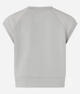 Remera deportiva de mujer color blanco hueso, con cuello redondo y mangas cortas tipo raglán con pespuntes visibles. Presenta un ruedo inferior más ancho y ajustado.