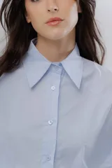 Camisa oversize celeste de algodón, con cuello camisero clásico y cierre frontal de botones.