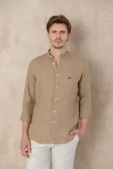 Camisa de lino color beige con cuello mao, corte slim fit y mangas 3/4 con botón para sujetar.