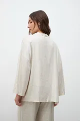 Kimono de corte holgado y diseño abierto, confeccionado en tejido con acabado laminado plateado. Presenta mangas anchas y bolsillos laterales aplicados.