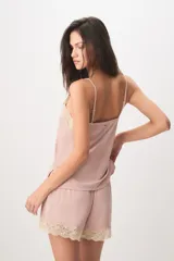 Pijama de dos piezas color verde menta, confeccionado en poliamida y elastano. Incluye una musculosa con tirantes finos y detalles de encaje beige en el escote, y un short con cintura elástica, pequeño lazo decorativo y apliques de encaje en los ruedos.