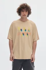 Remera unisex de algodón con ajuste oversized, cuello redondo, manga corta y estampado frontal con estrellas y texto.