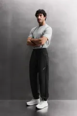 Pantalón jogger de entrenamiento regular fit confeccionado en tejido técnico compacto de algodón con elasticidad y efecto neopreno. Cuenta con cintura elástica ajustable con cordón, bolsillos frontales, un bolsillo lateral con cierre de cremallera y bajo acabado en puño.