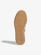 Championes Adidas Handball Spezial de diseño clásico, confeccionados en gamuza color crema con detalles de estampado animal print en las icónicas tres tiras y el talón. Presentan suela de goma color caramelo y logo dorado en el lateral.