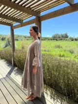 Vestido largo color verde oliva, de lino, con corte amplio, cuello mao, escote en V y mangas largas acampanadas.