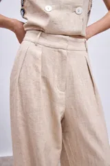 Pantalón de lino color beige, de corte palazzo con pinzas en la cintura.