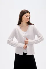 Cardigan de punto color natural, con escote en V profundo, cierre frontal con botones y mangas largas.