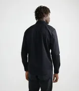 Camisa verde militar de manga larga en sarga de algodón, con cuello clásico, cierre frontal abotonado y dos bolsillos con solapa abotonada en el pecho.