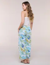 Pantalón crop de lino y rayón, con diseño wide leg de corte holgado, estampado tropical de hojas en tonos verde, azul y marrón sobre fondo blanco. Cuenta con pretina trasera elastizada y bolsillos delanteros.