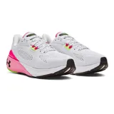 Championes de running Under Armour modelo HOVR Machina 3 para mujer. Diseño en color blanco con detalles en fucsia neón y verde lima. Presenta tecnología de amortiguación reactiva UA HOVR, refuerzo externo de TPU en el talón y suela de goma con canales de flexión para mayor durabilidad y retorno de energía.
